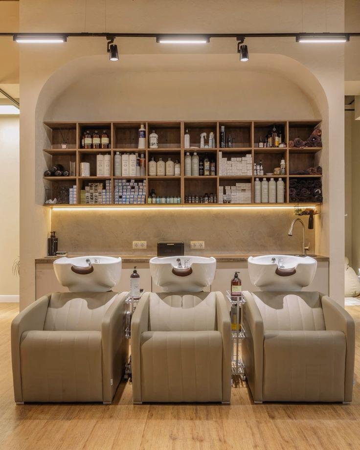 Three backwash chairs beneath a wall of shelved product