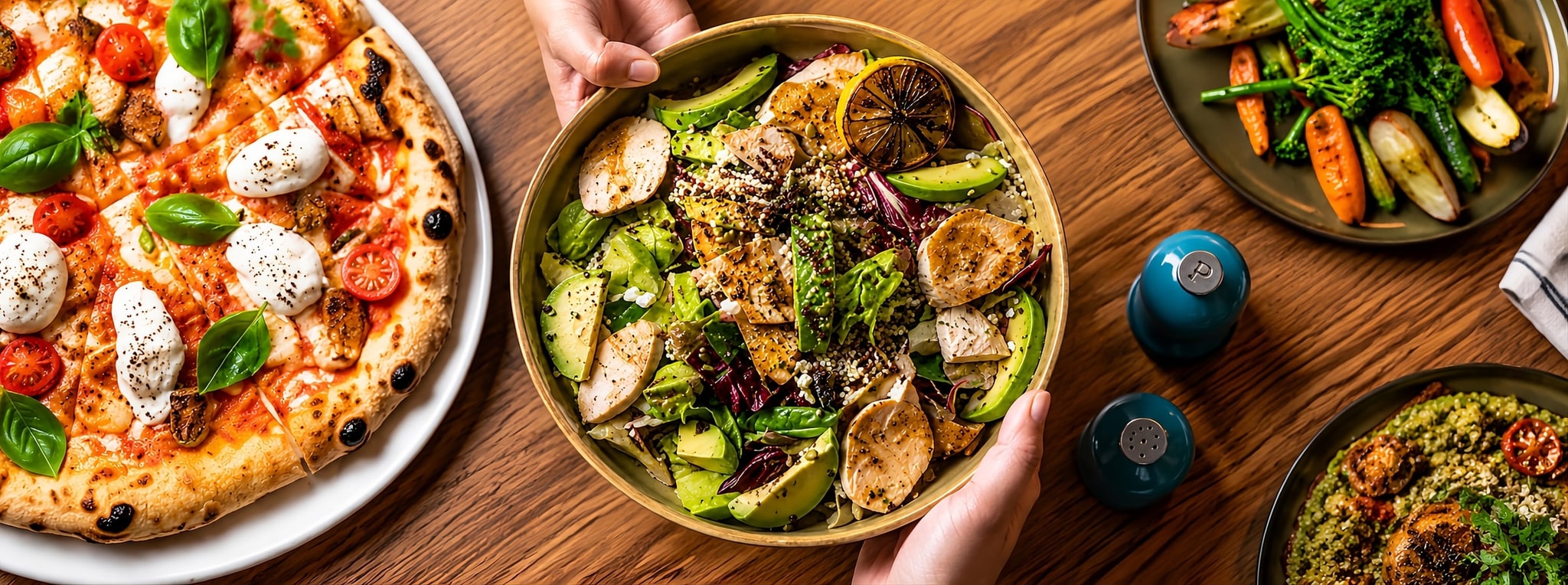 A shared table of pizza, grain bowls and roasted vegetables