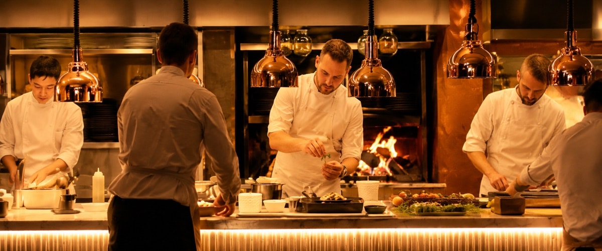 Cooks working an open kitchen pass
